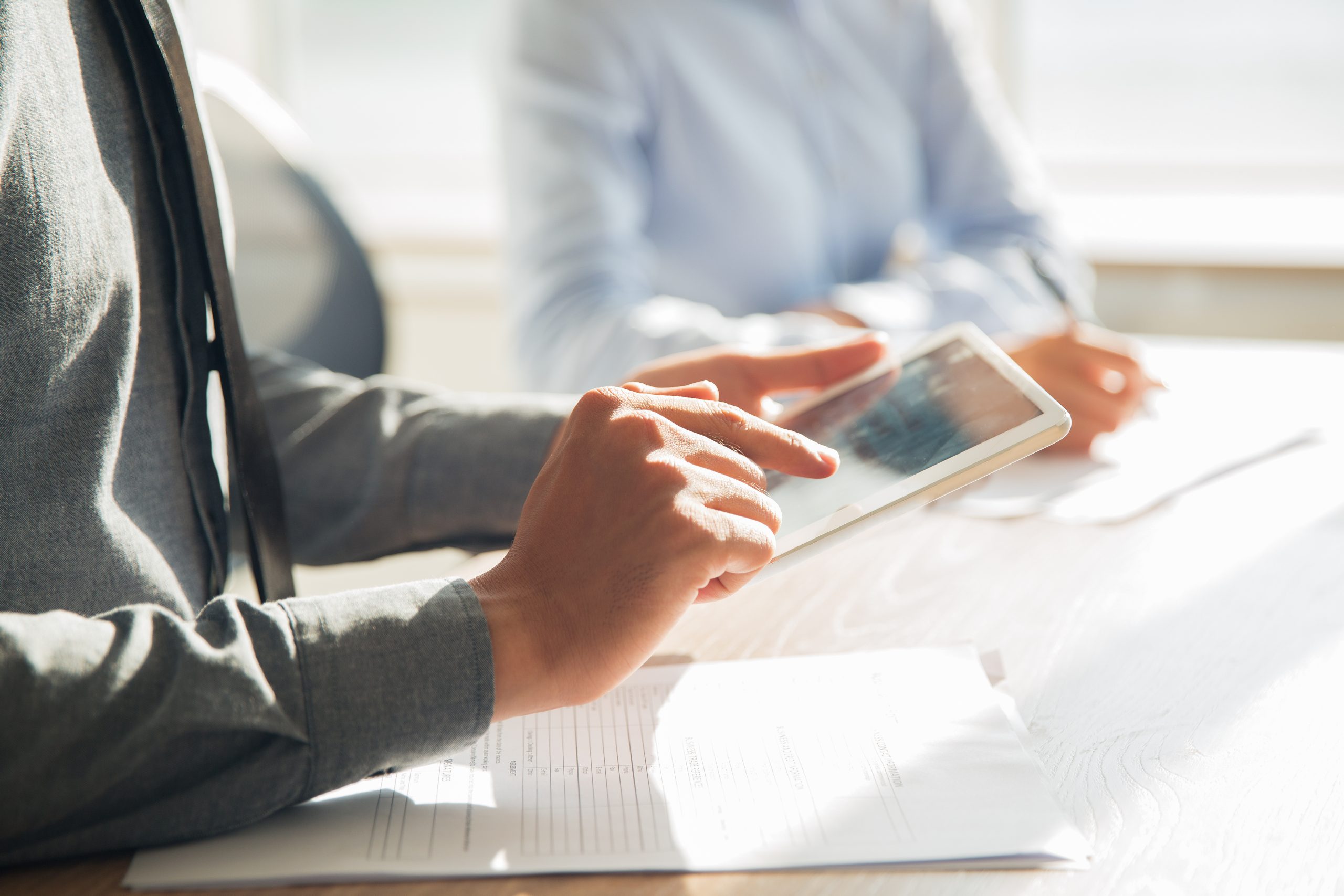 Profesional utilizando una tablet para gestionar trámites inmobiliarios y urbanísticos con los servicios de INFOPLAN